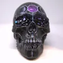 Black painted skull with metallic details in blue and purple featuring gem formations for the eyes & nose.