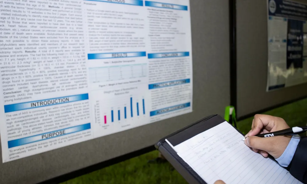 Visitor taking notes of a research poster. 