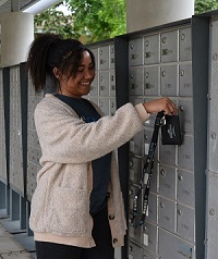 student opening up resident mailbox with key