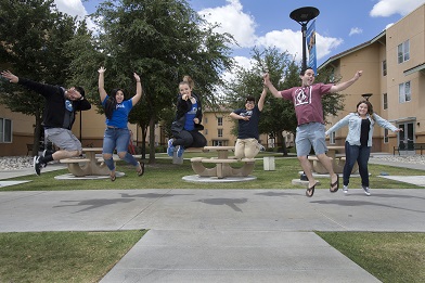 students jumping outside Arrowhead Village