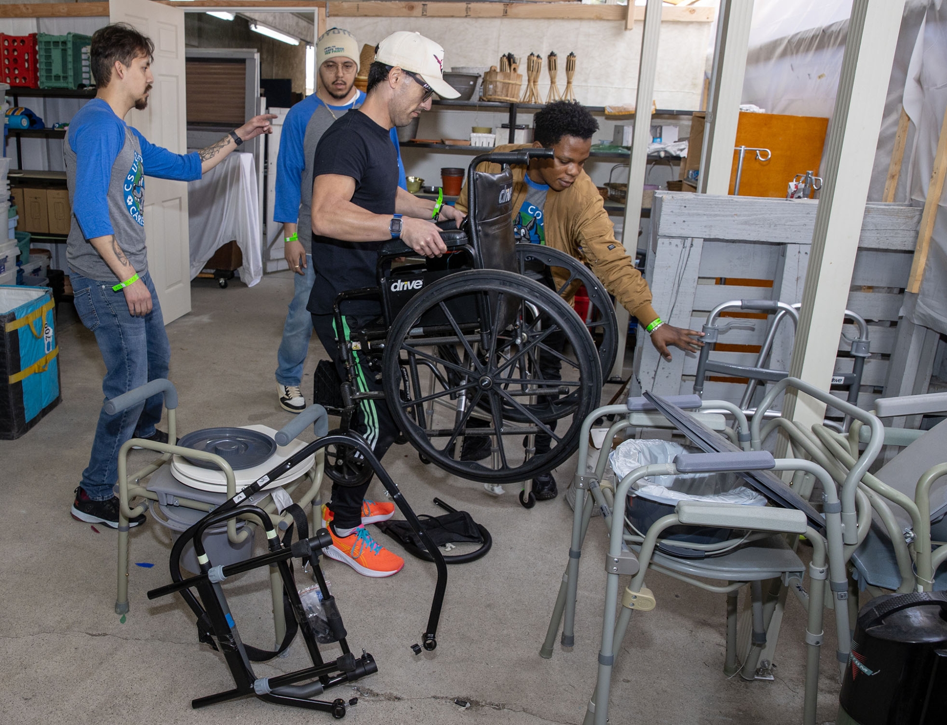 A group of volunteers helps organize wheelchairs and other equipment at a San Bernardino-area agency as part of CSUSB’s annual Coyote Cares Day.