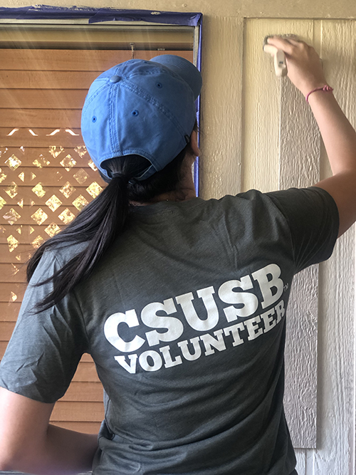 CSUSB student painting a mobile home for the Brush of Kindness.