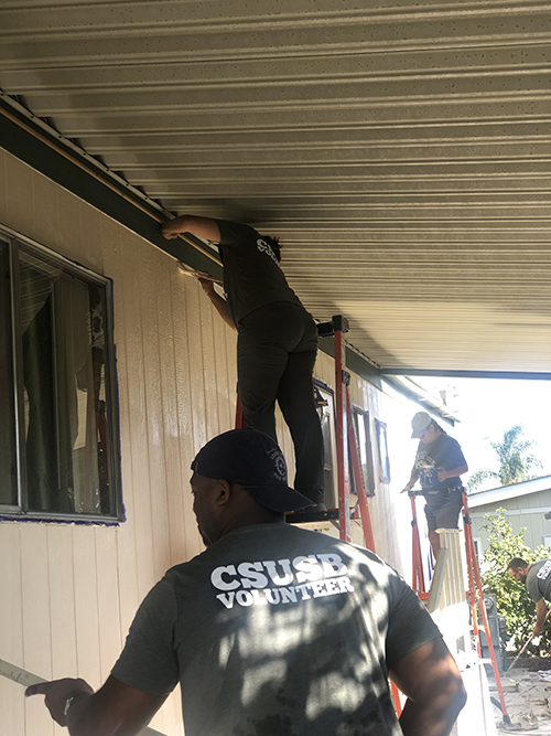 CSUSB volunteers painting a mobile home.