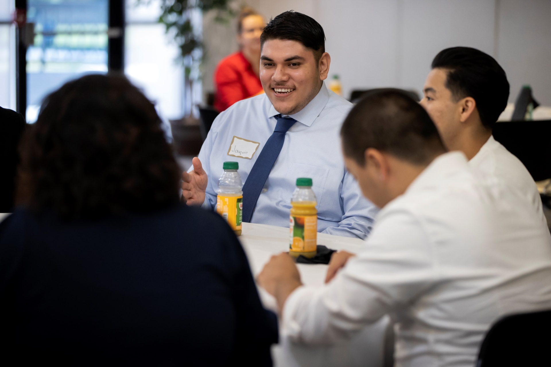 Students gathered around a table conversing. 