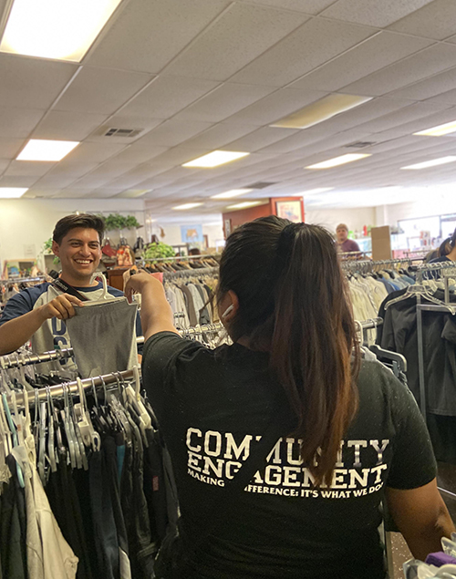 CSUSB sorting clothes at Martha's Village Store for day 3 of Camp SERVE.