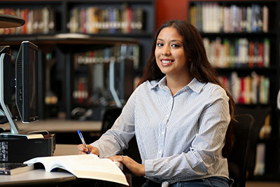 Woman posing for photo while writing