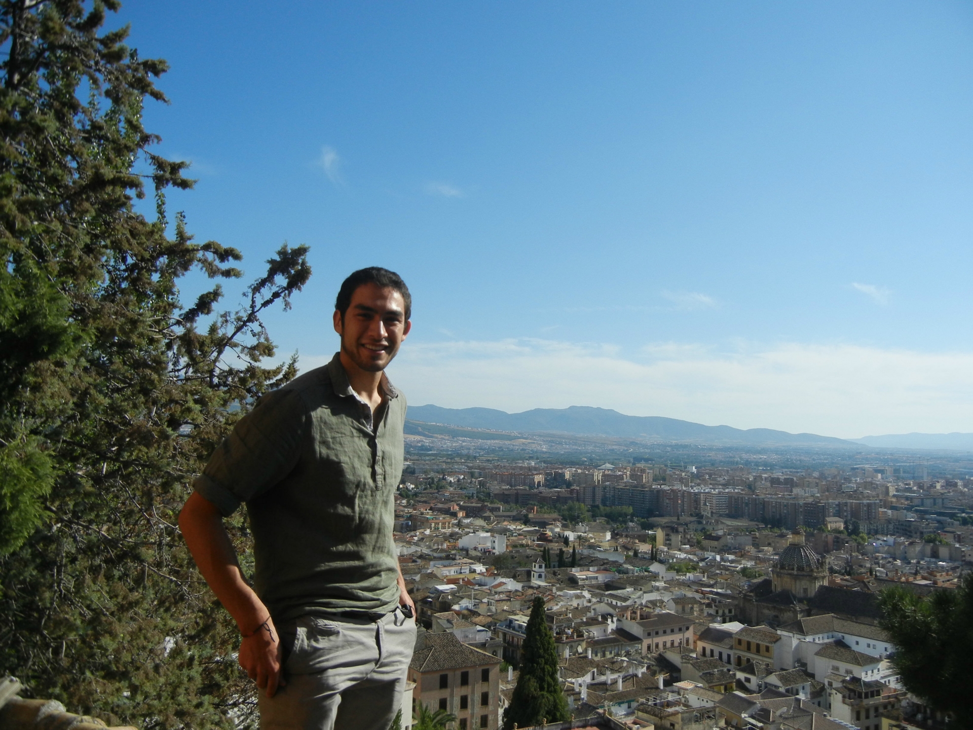 Daniel Robles standing atop a building overlooking a city in Spain.