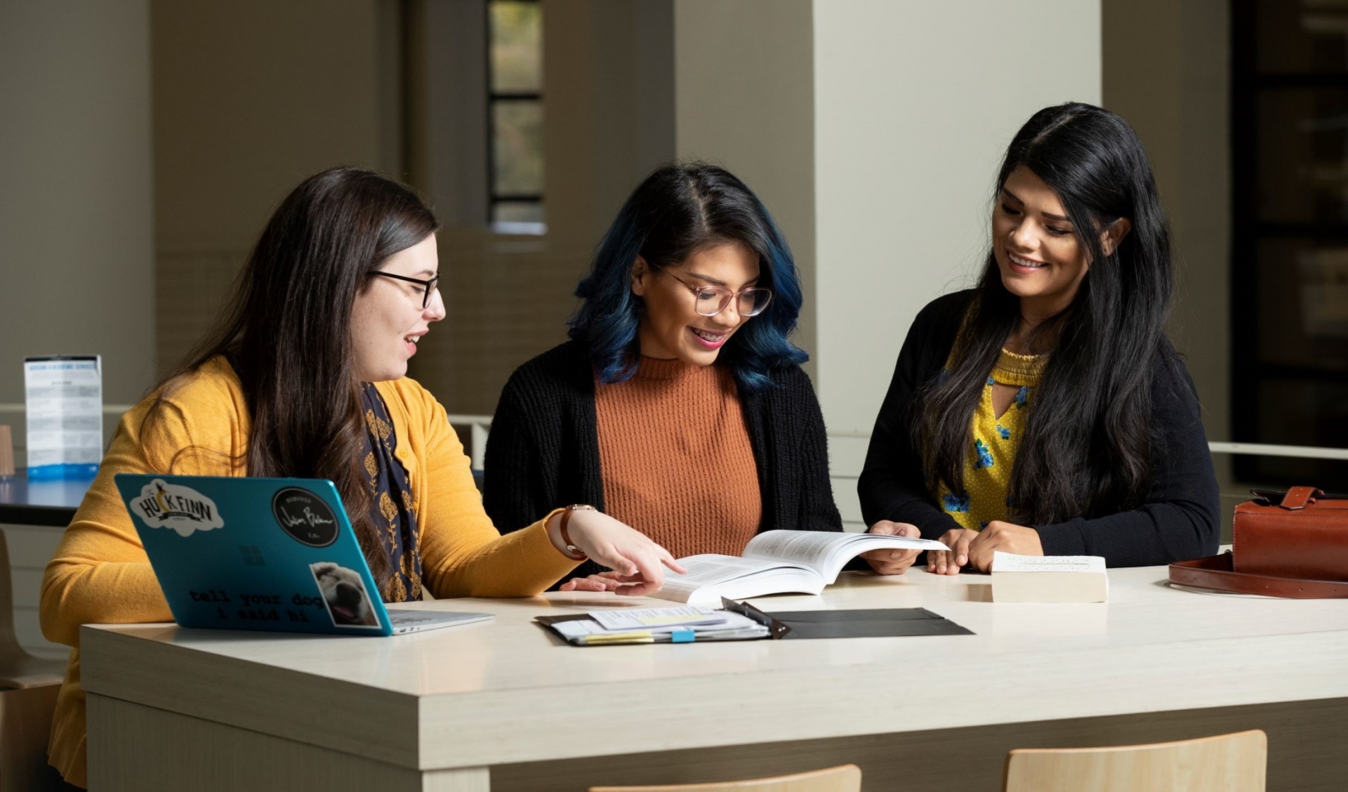 Three students studying at the library