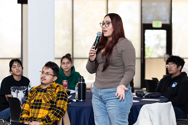 A woman speaks at the First-Generation College Celebration