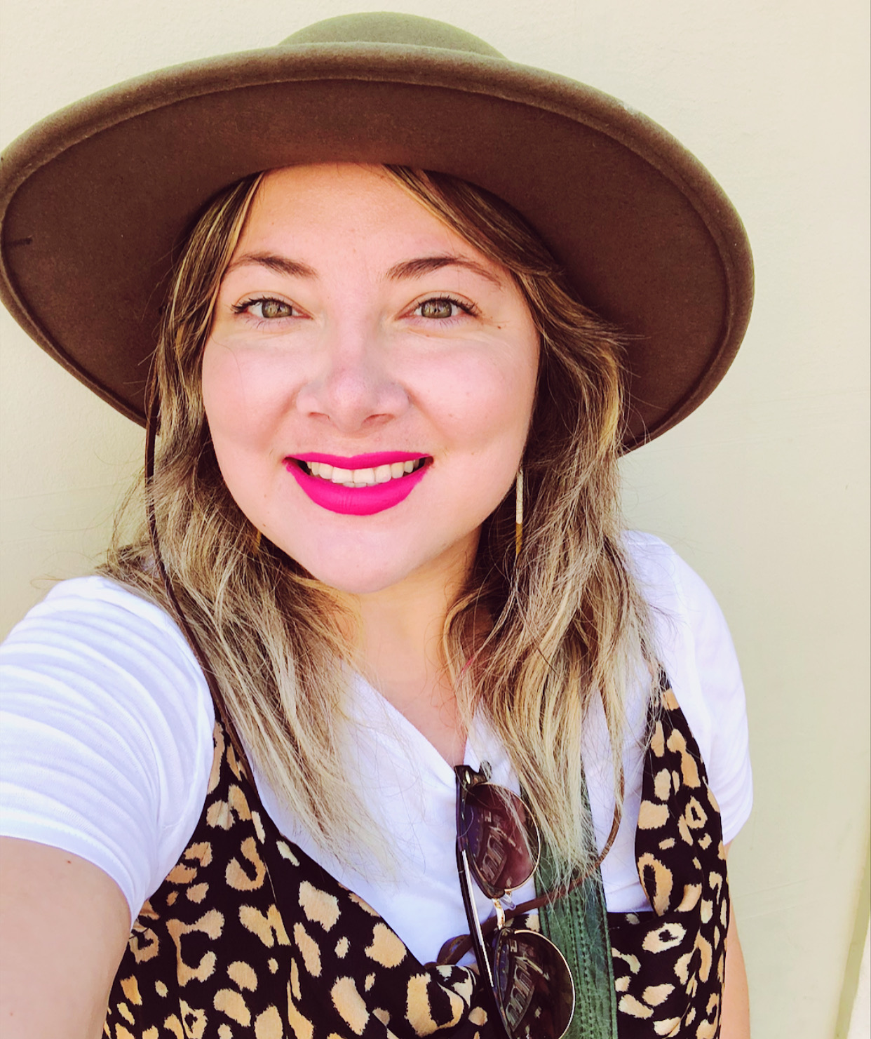 Jessica Carillo, with white shirt, pink lipstick and brown hat