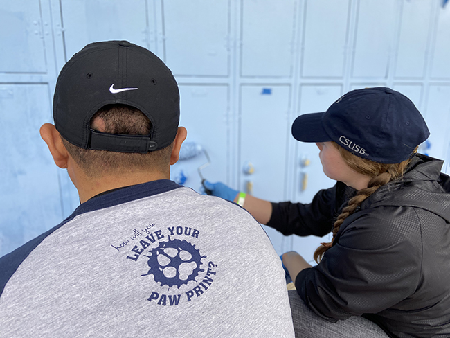 CSUSB volunteer painting at Orville Wright Middle School.