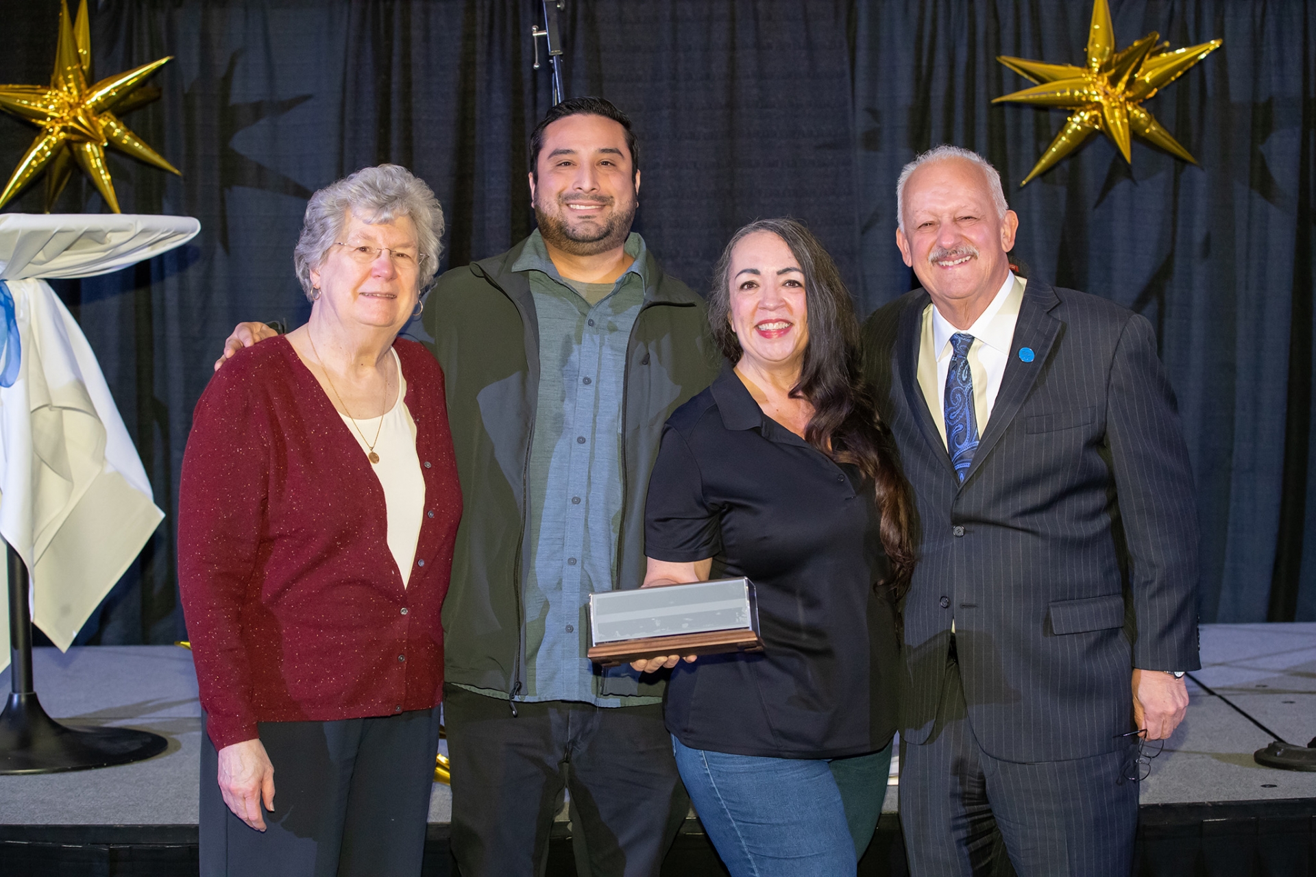 Pictured Carrie Hartung, widow of Augie Hartung, Jaime Espinoza, chair of the Staff Council Executive Board, Lisa Gordon, recipient of the Augie and CSUSB President Tomás D. Morales. 