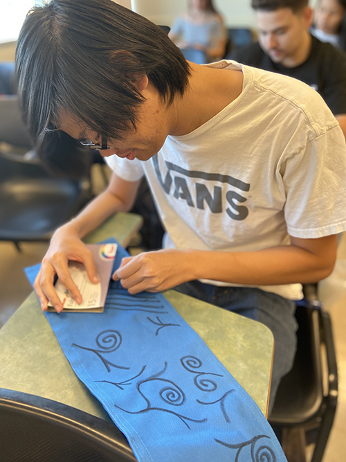 CSUSB PDC student decorating the duffel bag for Make A Difference Day.