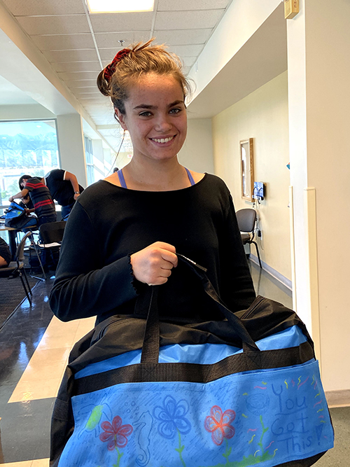 CSUSB PDC student showing off her decorated duffel bags.