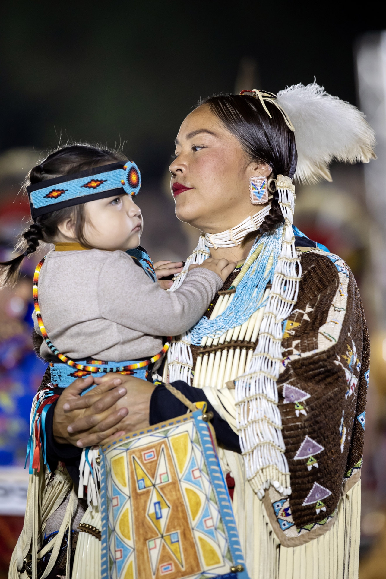 Pow Wow performer holding a child