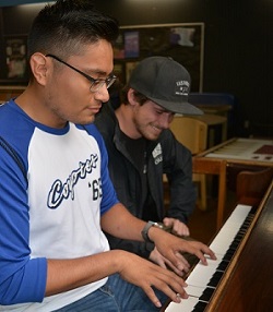 two male roommates playing piano