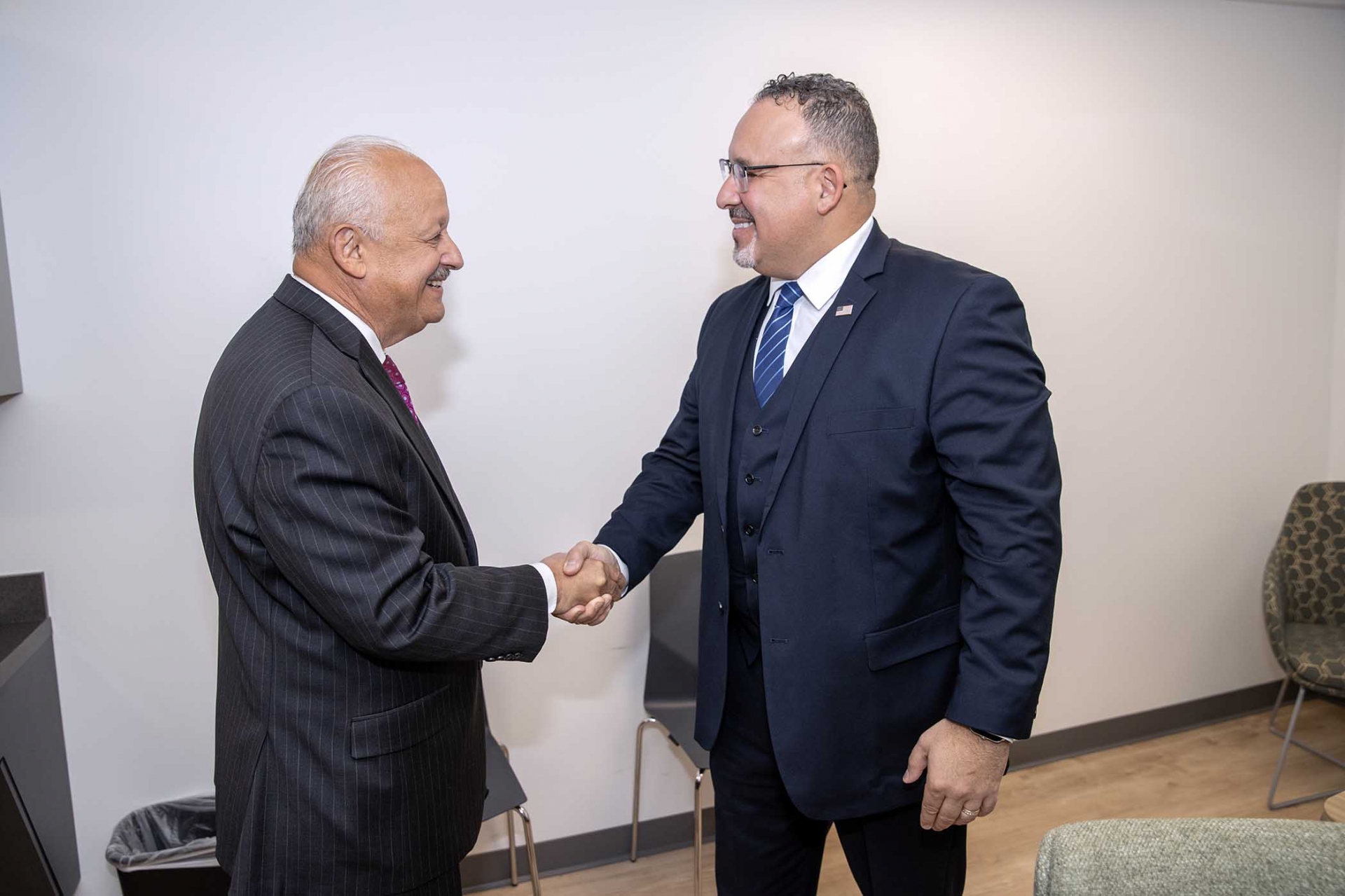 CSUSB President Tomás D. Morales (l) greets U.S. Secretary of Education Miguel Cardona.