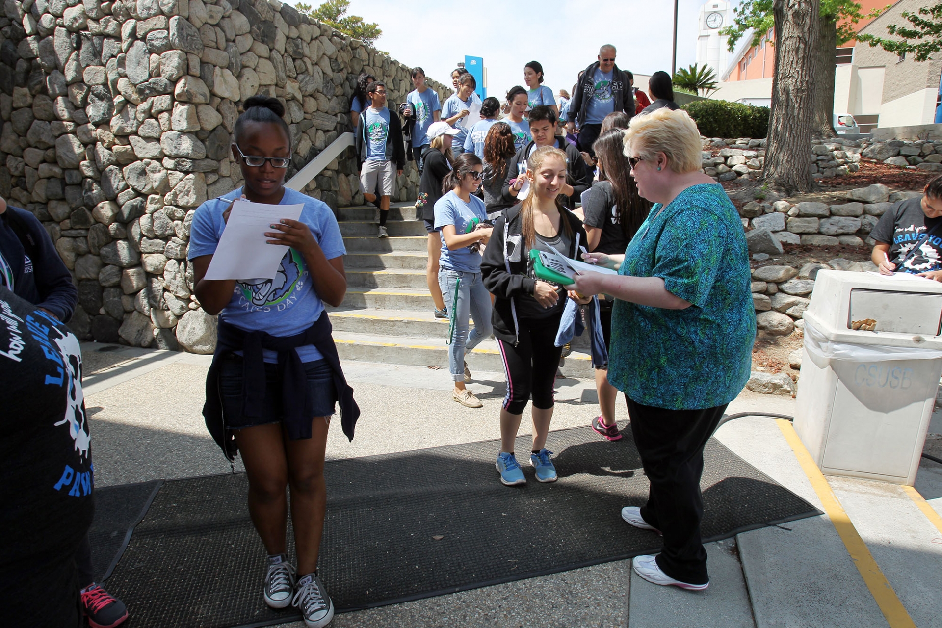 Diane Podolske (right) greets students as they make their way out to the community during the 2014 Coyote Cares Day.