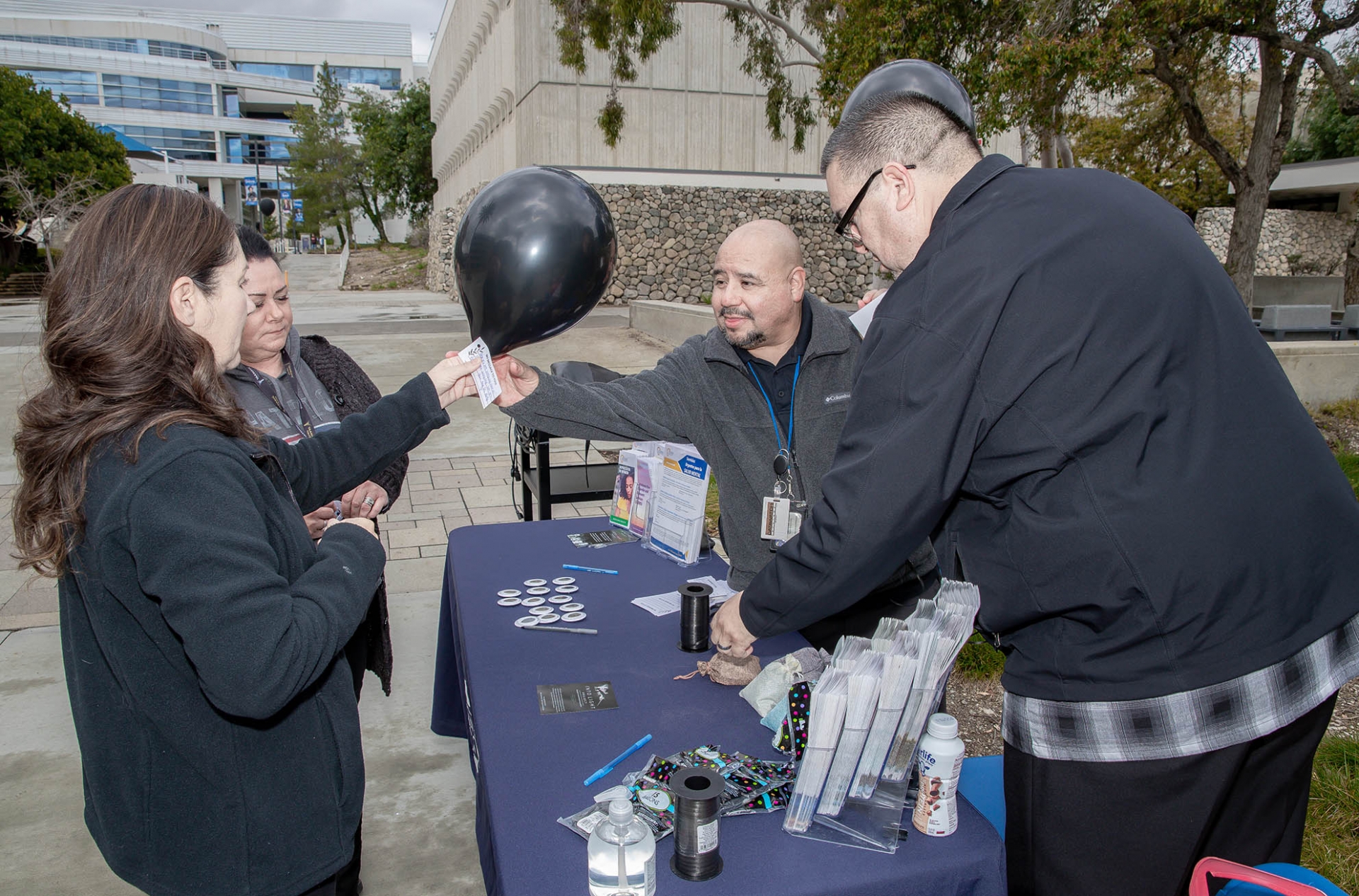 San Bernardino County Social Services staff members Alex Cordova (second from right) and Enrique Gonzalez met with the Coyote community on March 6 on Coyote Walk during Black Balloon Day, aimed bring awareness to the dangers of drug overdoses and substance use disorder.