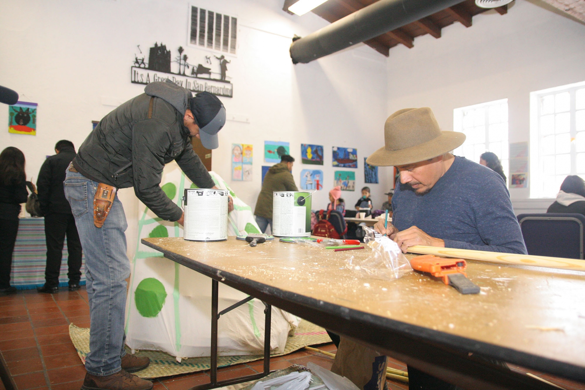 Esteban Zúñiga (at right), a Los Angeles-based artist, constructs a turtle costume.