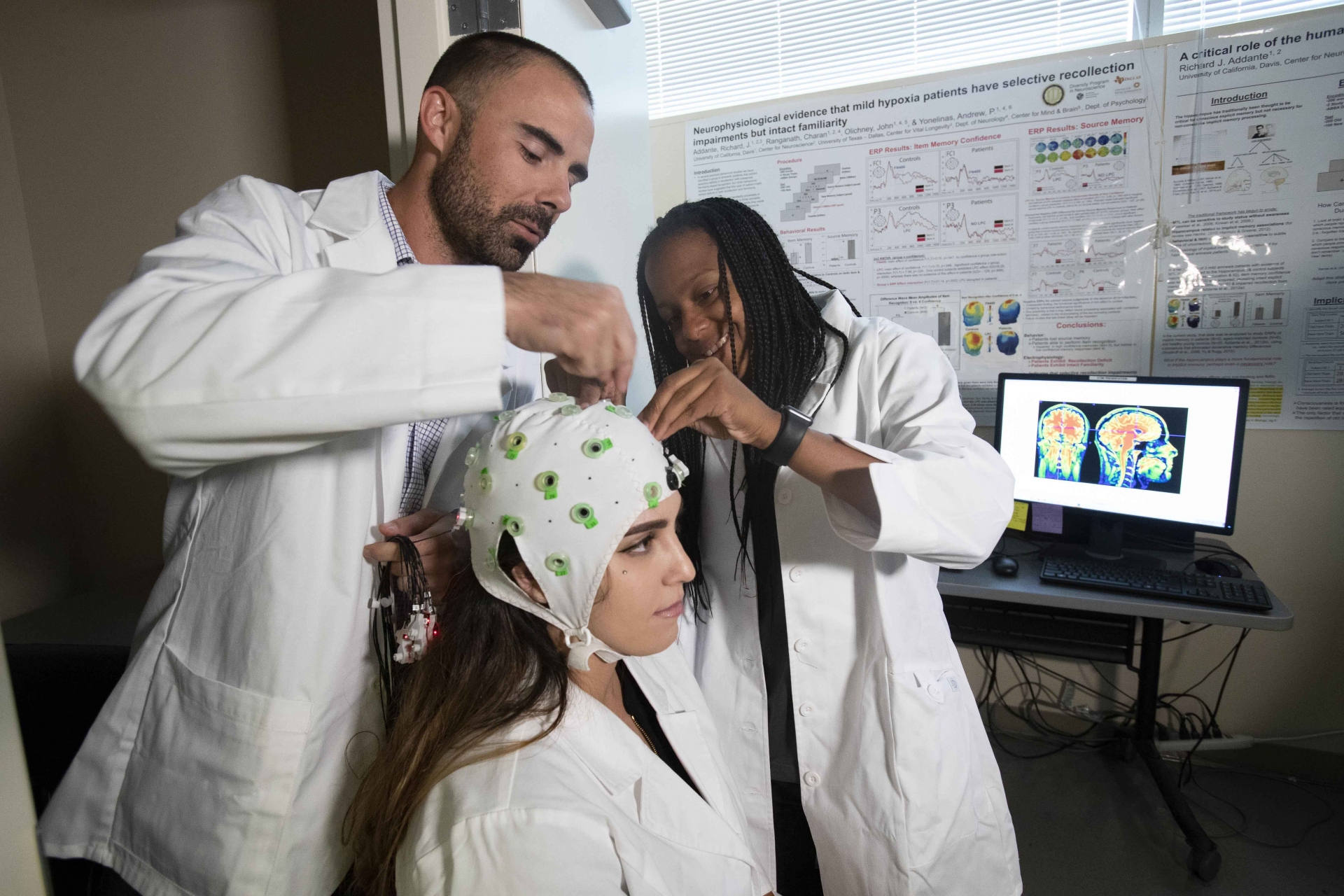 Richard Addante and Constance Greenwood make adjustments to an EEG device worn by Raechel Marino. The Addante and the students are developing a mobile EEG device that can be worn by astronauts to measure their brain activity.