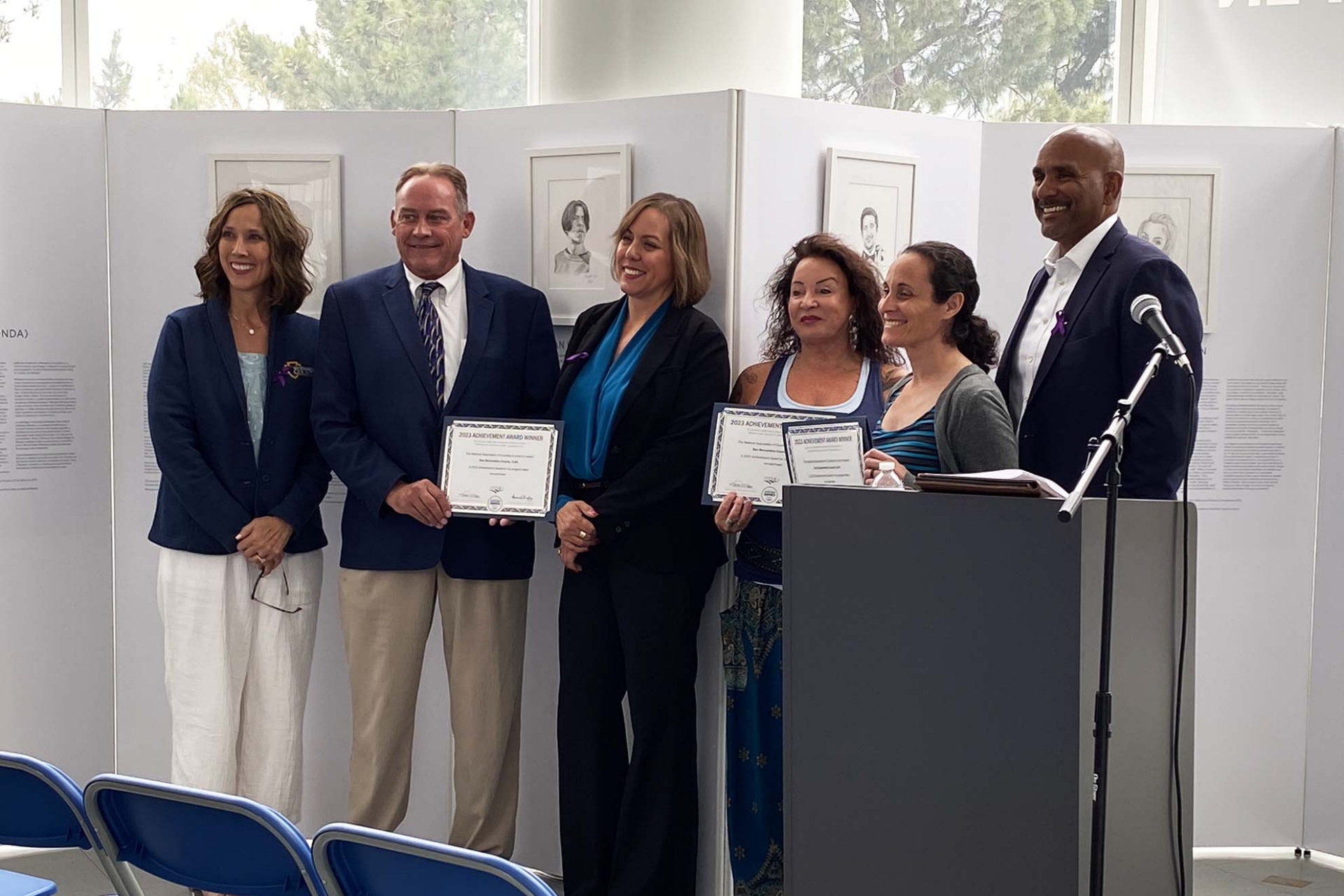 Representatives from San Bernardino County, the INTO LIGHT Project and Cal State San Bernardino hold certificates of achievement. The National Association of Counties (NACo) selected the California INTO LIGHT exhibition for an Achievement Award in the Arts, Culture and Historic Preservation Category for 2023.
