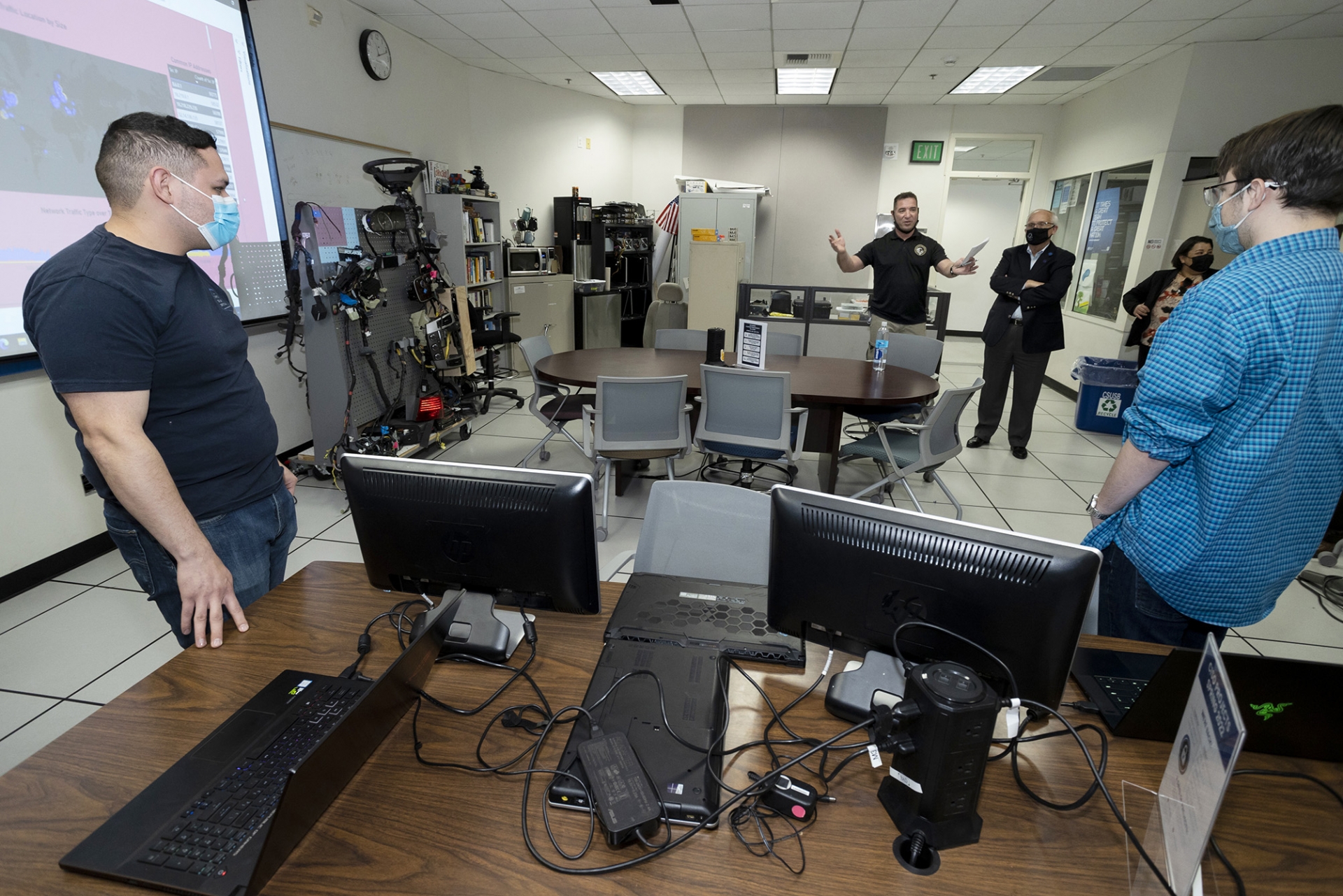 Vincent Nestler (arms spread) with California State University Trustee Larry L. Adamson, during Adamson's visit to the Cybersecurity Center in March 2022.