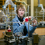 Photo of person using chemistry equipment in lab