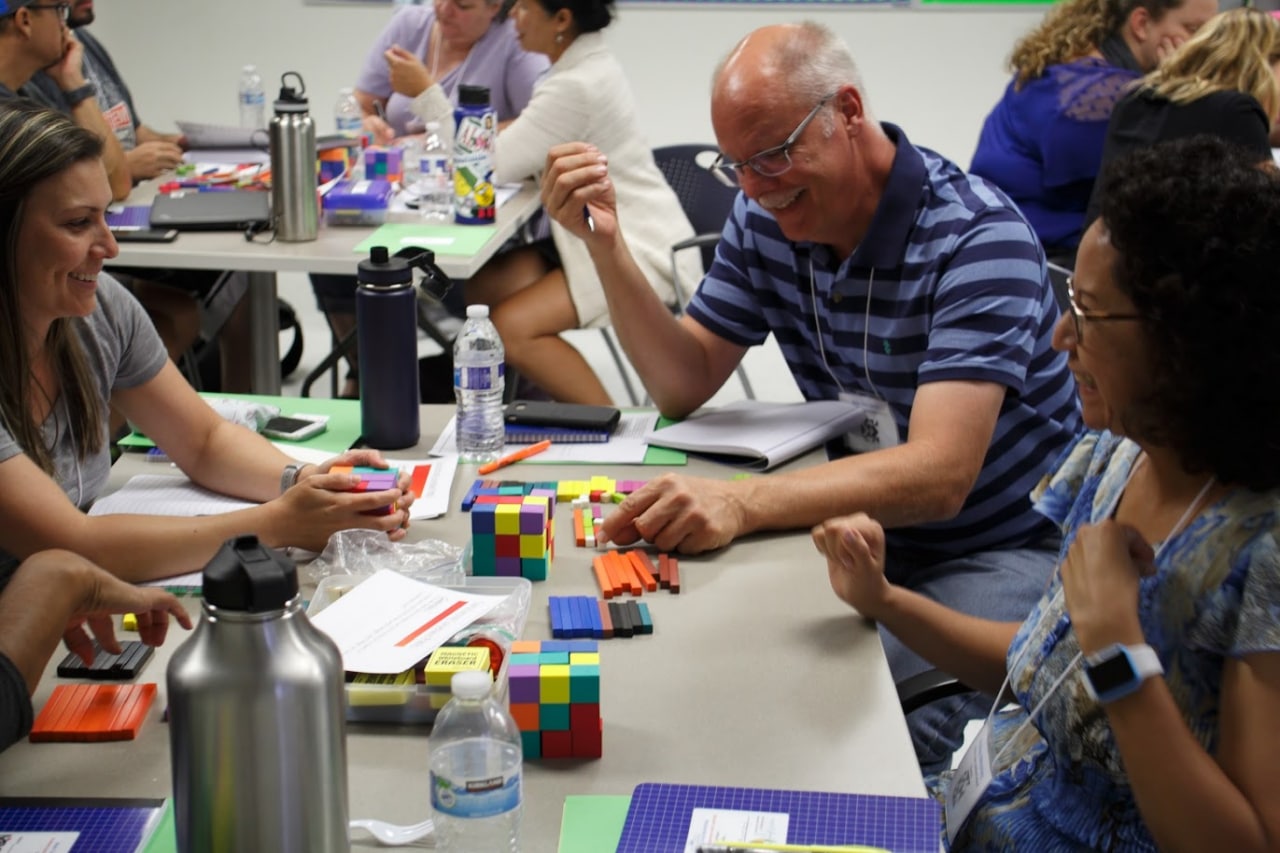 People working on a math problem at a table