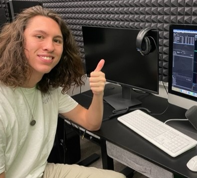 A smiling student gives a thumbs up while using the Innovation Studio.