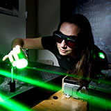 Photo of student conducting an experiment using lasers