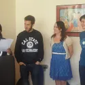 People listening to lady with paper speaking