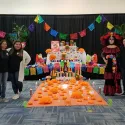 Club members, Advisor and a student dressed as la Catrina stand by the alter they created