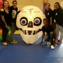 Students around a giants calavera