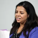 Woman holding papers speaking