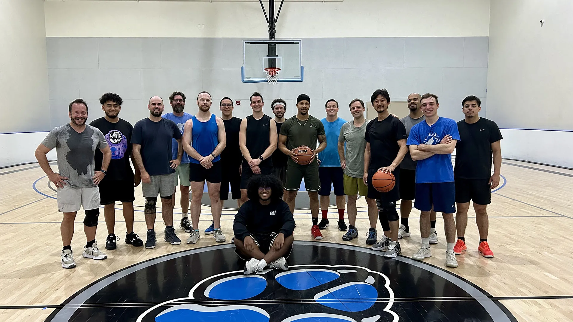A group of CSUSB students, faculty and staff at the Recreation and Wellness Center basketball court after a game. The informal pickup games are continuing through the summer. More players are welcome.