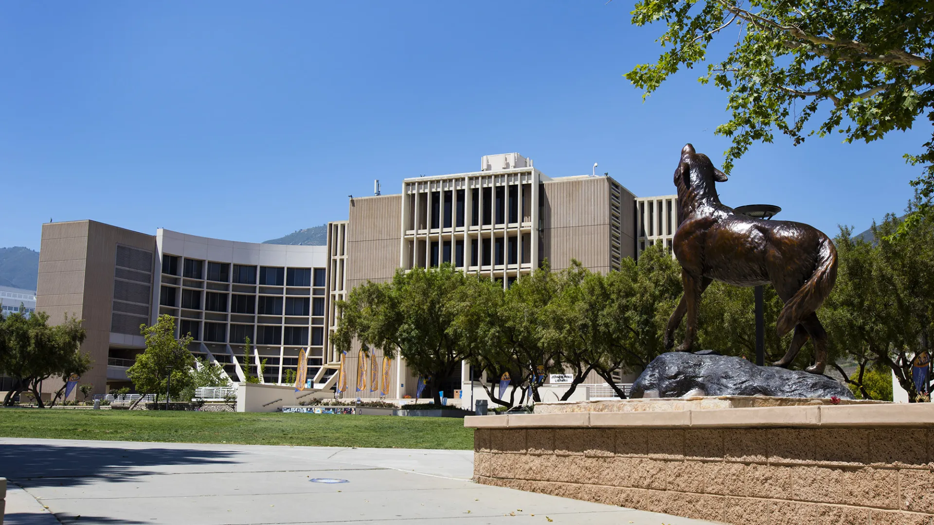 The Wild Song statue on the CSUSB campus with the John M. Pfau Library in the background.