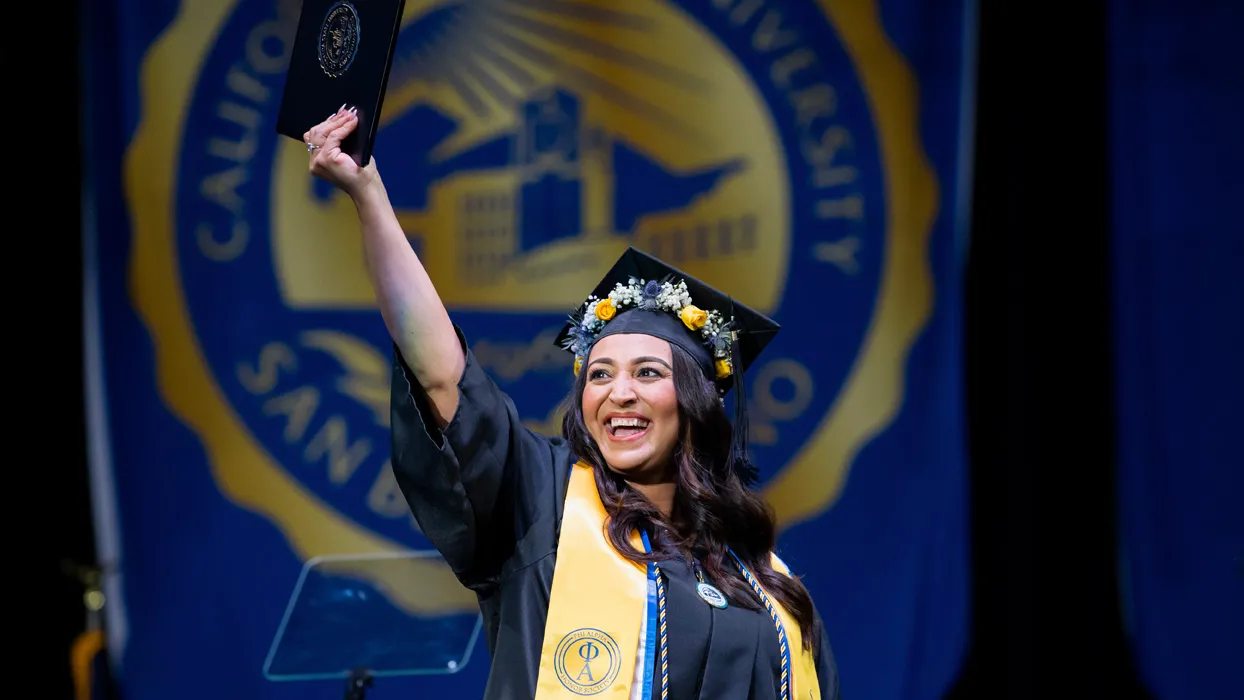 A graduate celebrating at CSUSB’s College of Social and Behavioral Sciences Spring Commencement ceremony held in May.