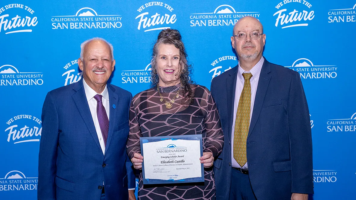 During the June 30 Faculty Recognition Luncheon, CSUSB President Tomás D. Morales (left) presented the 2025 Emerging Scholar Award to Elizabeth Castillo, who is also posed with Tomás Gomez-Arias, dean of the Jack H. Brown College of Business and Public Administration. 