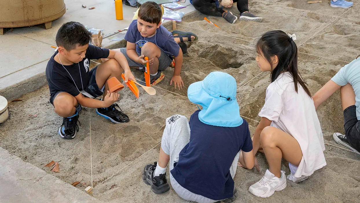 Children playing in a sand box during the 2024 Kids Discover Eygpt Workshop at CSUSB.