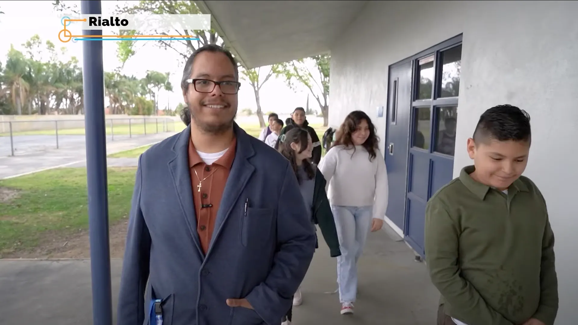 Jacobo Lopez (left), a Project Impact graduate, walks with some of his students at the Rialto elementary school where he now teachers, in a clip from the “Inside California Education” report, “Project Impact: Diversifying the Teacher Workforce.”