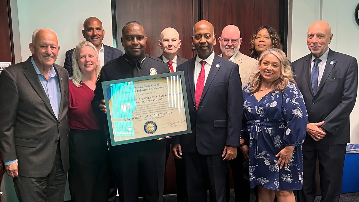 CSUSB Police Chief John Guttierez, surrounded by university administrators, holds a plaque from the International Association of Campus Law Enforcement Administrators that officially recognizes that the University Police Department has been accredited.