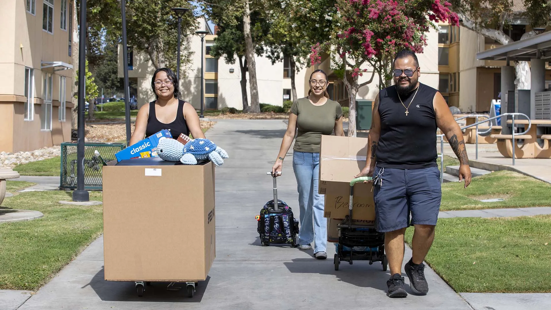 Three people moving items to a CSUSB residential hall on one of three Move-in Days before the start of the 2026 fall semester.