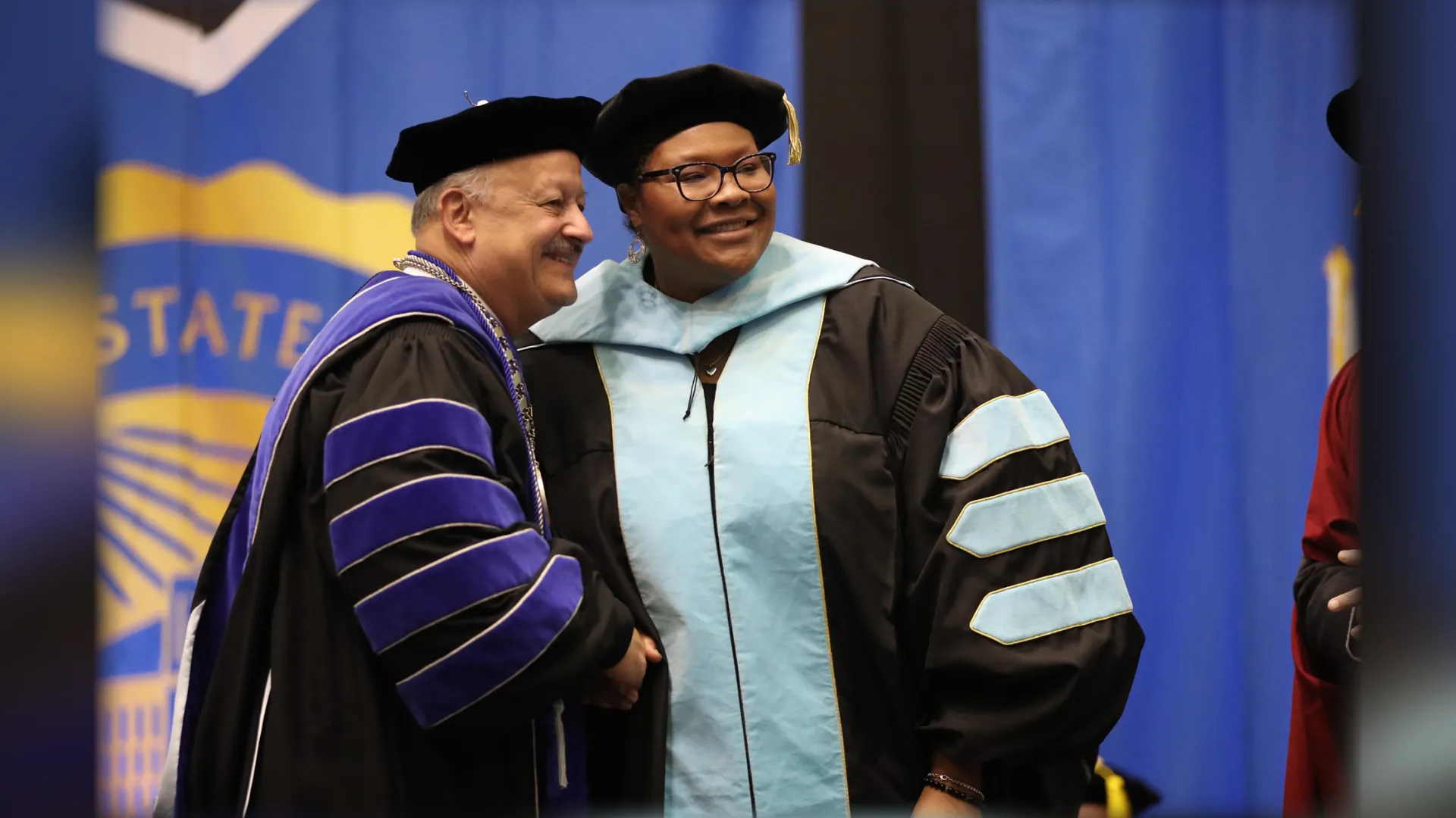 Cherina Betters (right) is congratulated by CSUSB President Tomás D. Morales upon receiving her Ed.D. degree.