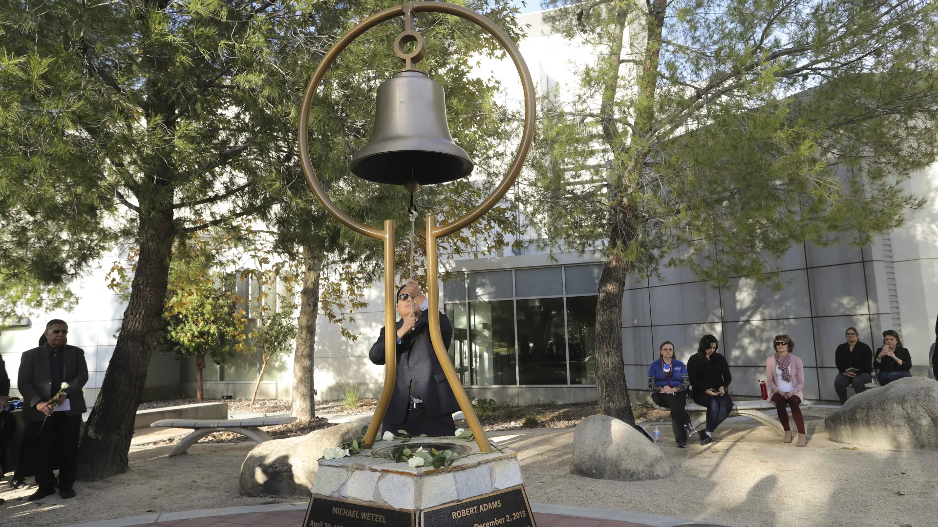Michael Nguyen rings the bell during the 2019 Day of Remembrance at the university’s Peace Garden