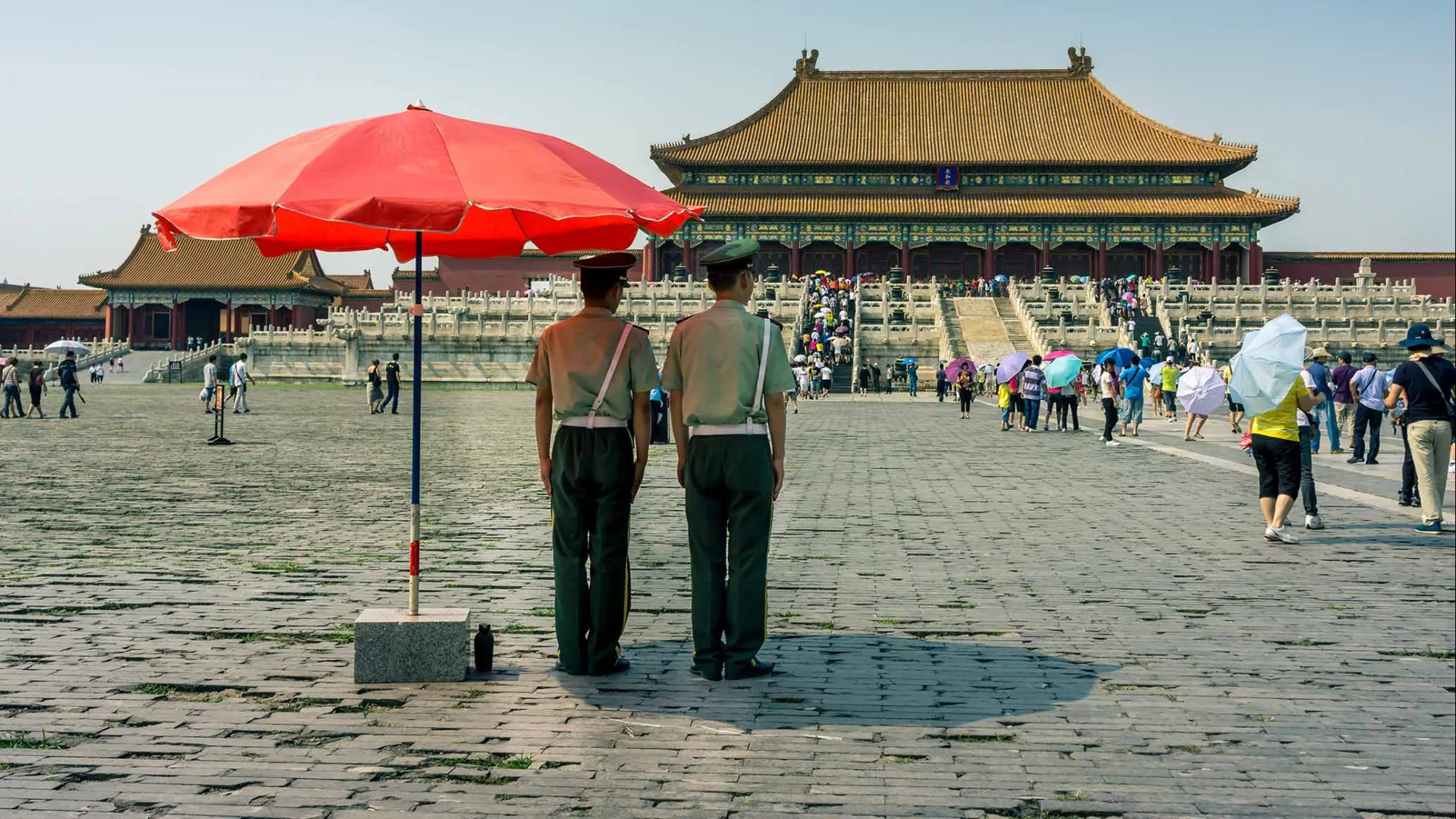 Police officers watch over visitors to the Forbidden City in Beijing, China.