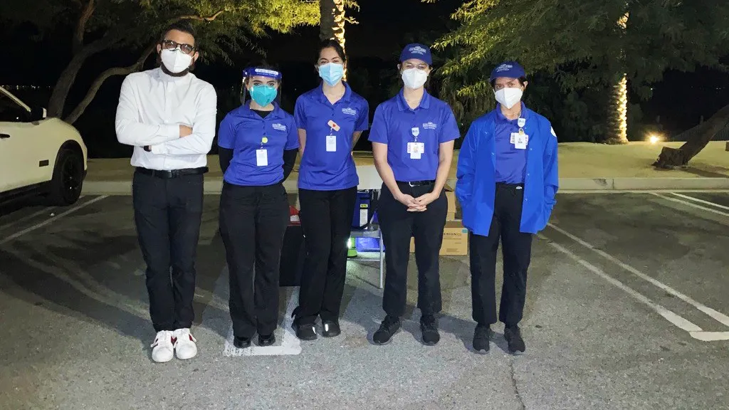 Four CSUSB Palm Desert Campus nursing students (in the blue tops) provide flu shots at a drive-thru flu shot clinic at the North Shore Beach and Yacht Club at the Salton Sea.