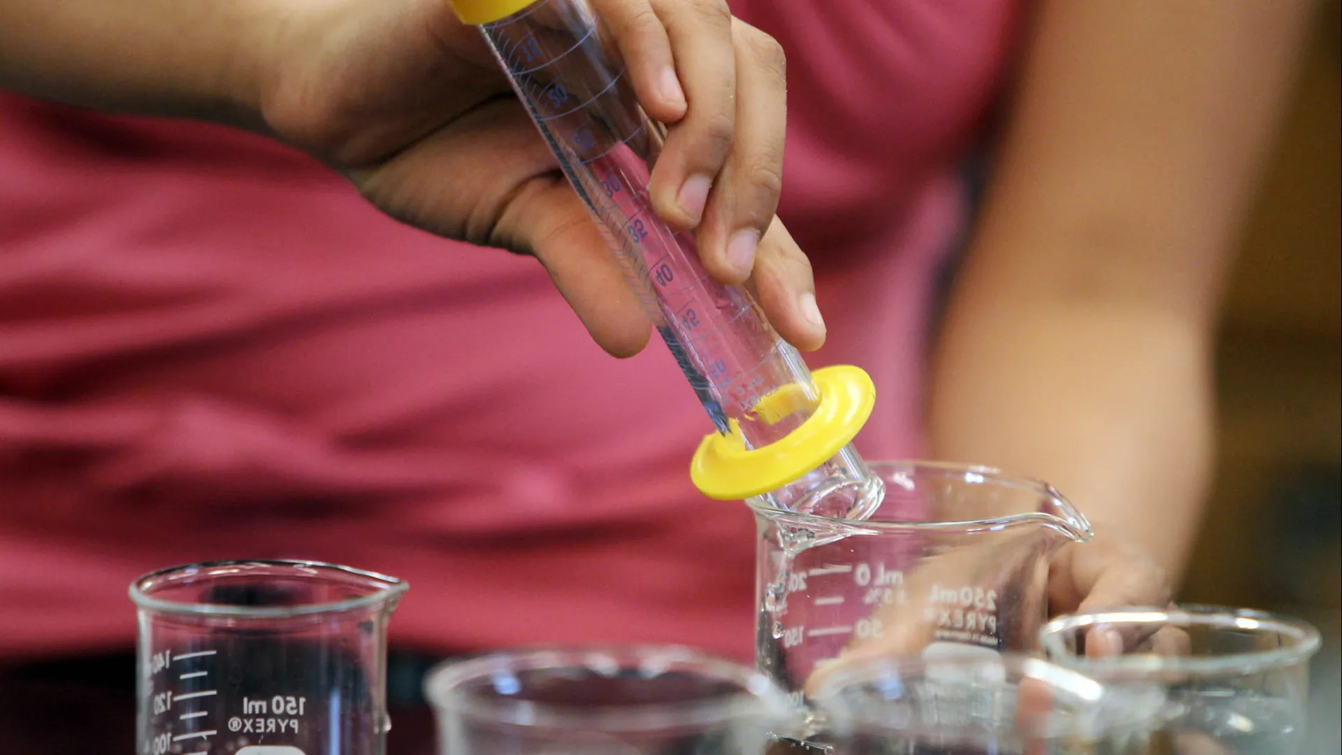 Student’s hands shown working in a lab setting