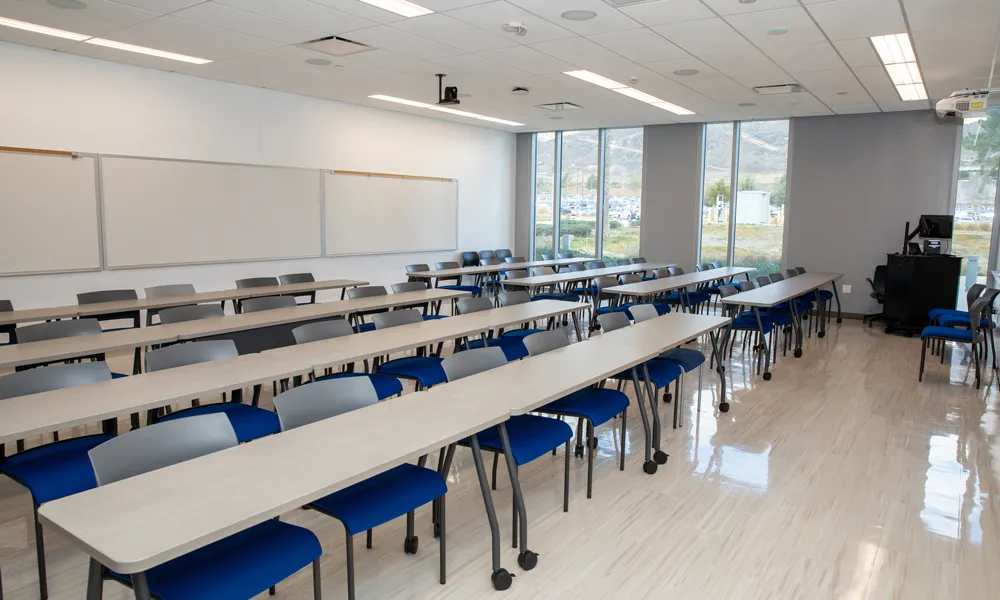 An inviting collaboration area with seating, a whiteboard, AV capabilities and ample natural light.