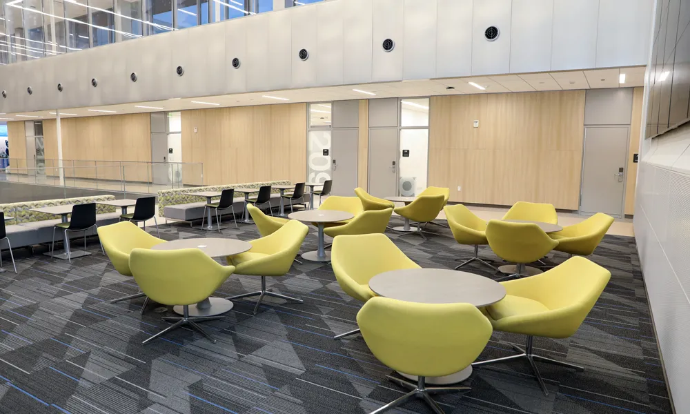 A spacious, modern event room with a comfortable furniture, featuring a state-of-the-art media wall.